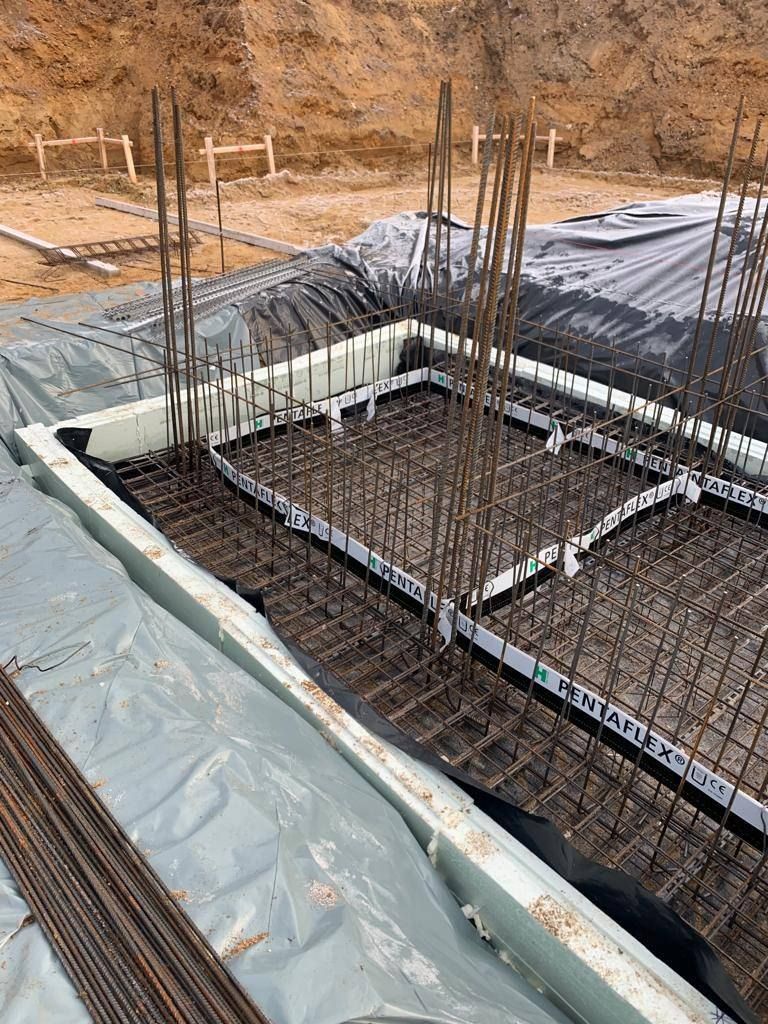 Bewehrungskorb einer Fundamentplatte mit Randschalung auf der Baustelle