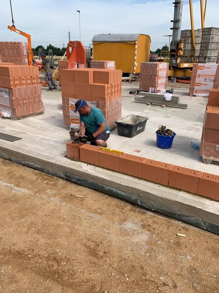 Maurer setzt Klinkerriemchen an einer Verblendfassade