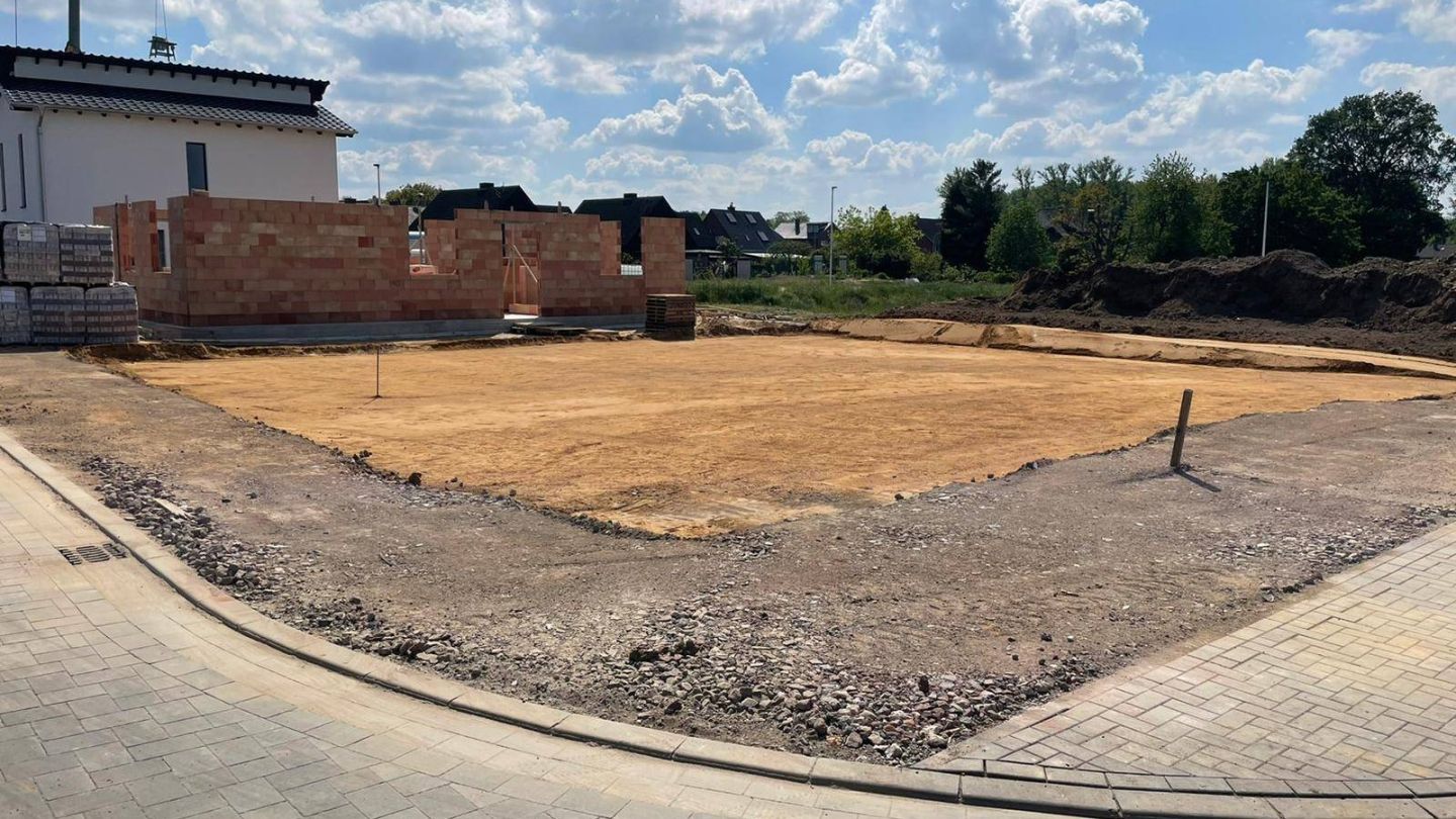 Rohbau eines Wohnhauses aus rotem Klinkermauerwerk auf einer offenen Baustelle im Kreis Heinsberg